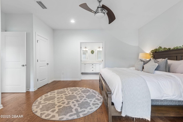 bedroom with connected bathroom, ceiling fan, baseboards, wood finished floors, and visible vents