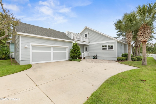 view of front facade with a garage, a front yard, driveway, and a balcony