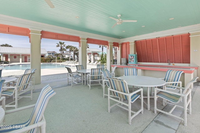 view of patio / terrace featuring a community pool, a ceiling fan, and outdoor dining space