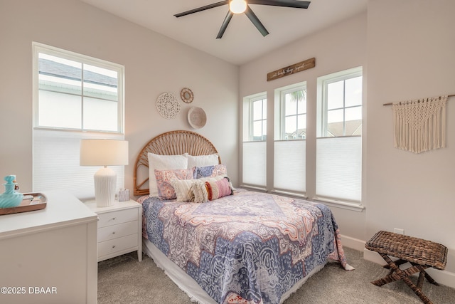 bedroom with light colored carpet, baseboards, and a ceiling fan