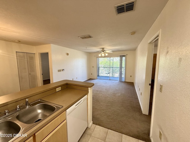 kitchen featuring white dishwasher, light carpet, a sink, visible vents, and a ceiling fan