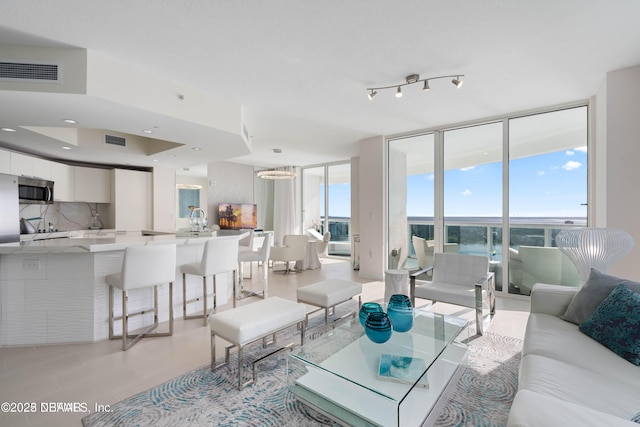 241 Riverside Dr Unit 2301, Holly Hill, FL 32117 - living area featuring visible vents, light wood-style flooring, an inviting chandelier, and floor to ceiling windows