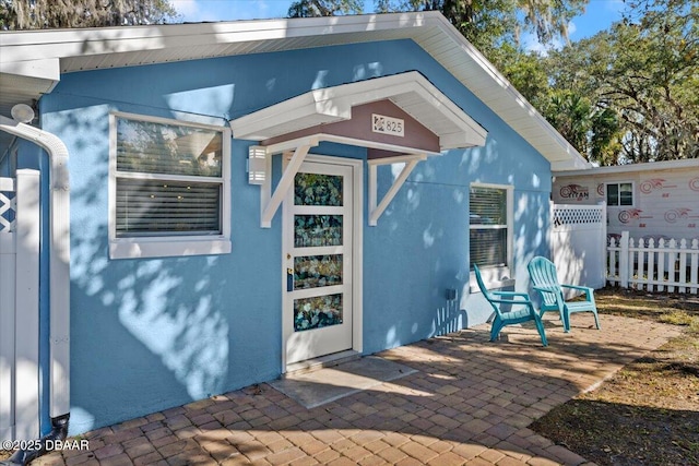 view of exterior entry with a patio