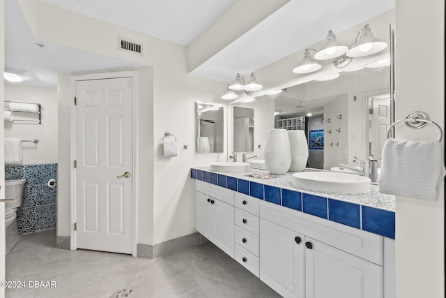 bathroom featuring toilet, vanity, and tile patterned flooring