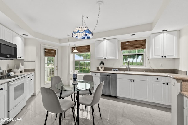 kitchen featuring stainless steel appliances, white cabinetry, and a healthy amount of sunlight