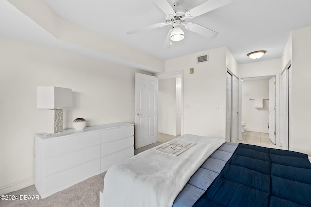 bedroom with connected bathroom, a closet, light carpet, and ceiling fan