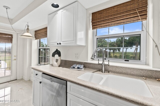 kitchen featuring stainless steel dishwasher, sink, and white cabinets