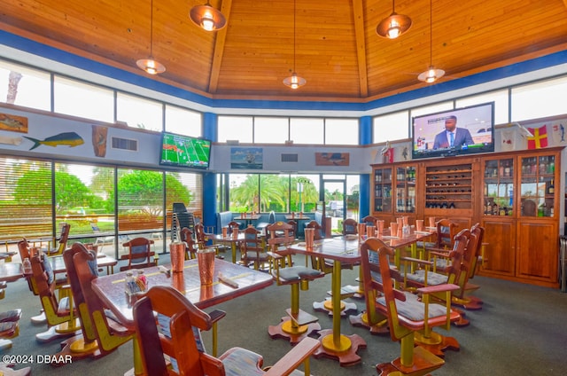 dining room with high vaulted ceiling, plenty of natural light, and carpet floors