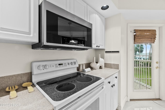 kitchen with white cabinetry, light tile patterned floors, and white range with electric stovetop