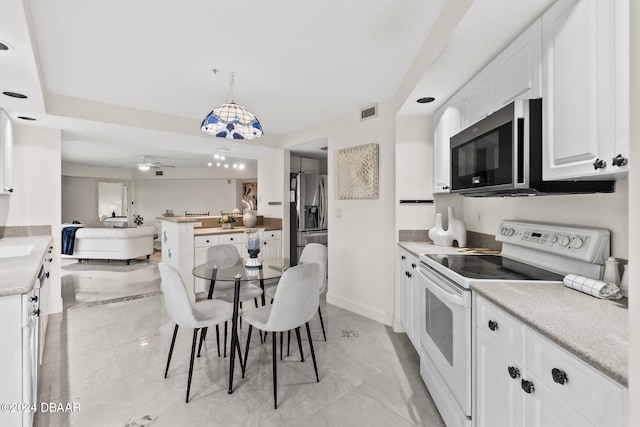 kitchen featuring white cabinets, ceiling fan, decorative light fixtures, and appliances with stainless steel finishes