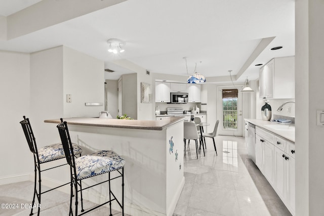 kitchen featuring kitchen peninsula, hanging light fixtures, sink, white cabinetry, and appliances with stainless steel finishes