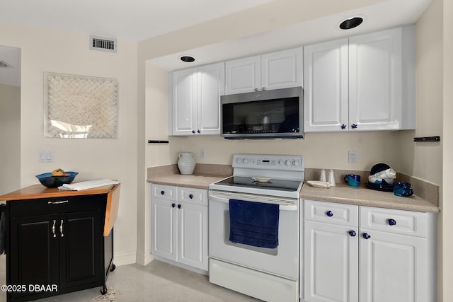 kitchen with white cabinets, stainless steel microwave, visible vents, and white electric range