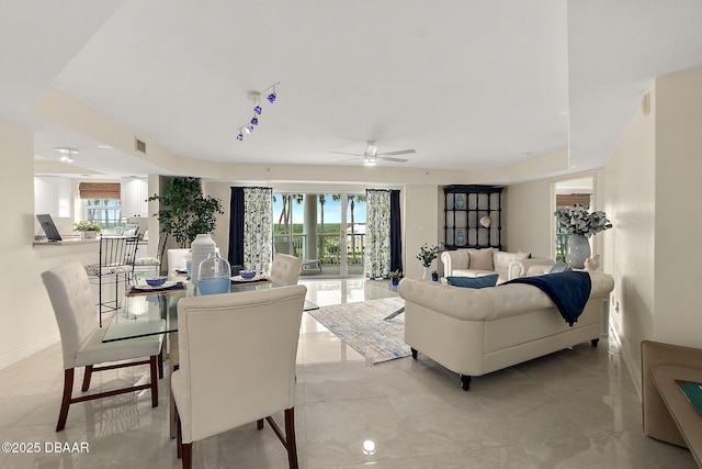 living area featuring a ceiling fan, visible vents, and baseboards