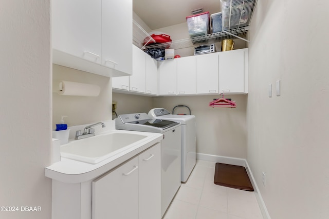 laundry room featuring cabinets, light tile patterned floors, sink, and washer and dryer