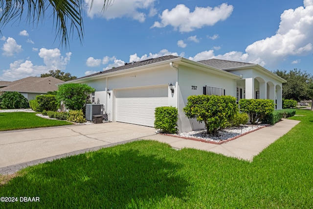 view of side of home featuring a lawn, central air condition unit, and a garage