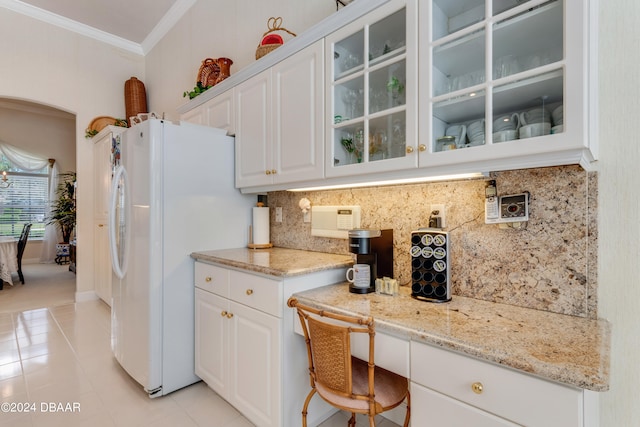 kitchen featuring white cabinets, light tile patterned flooring, white fridge with ice dispenser, and crown molding