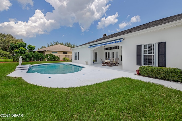 view of pool with a patio, a lawn, and french doors