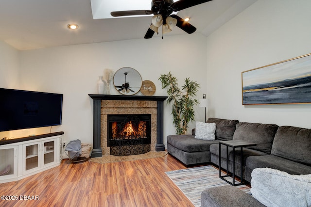 living room featuring lofted ceiling, ceiling fan, and wood-type flooring