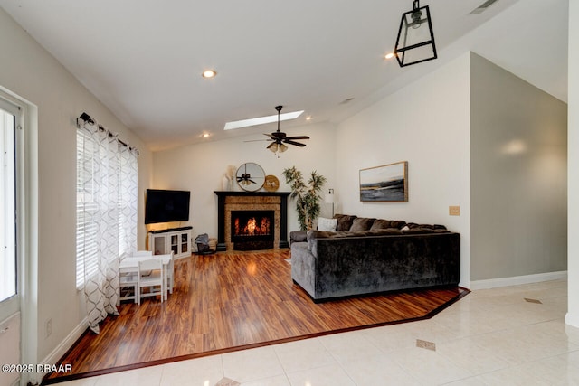 tiled living room with lofted ceiling and ceiling fan