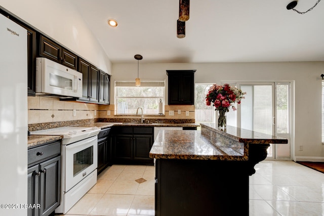 kitchen with white appliances, a center island, backsplash, and sink