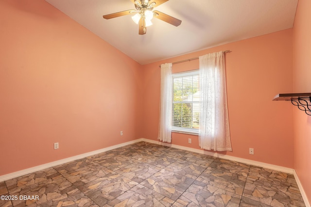 1927 Orange Tree Dr, Edgewater, FL 32141 - empty room with stone finish floors, a ceiling fan, lofted ceiling, and baseboards