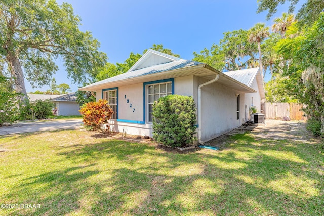 1927 Orange Tree Dr, Edgewater, FL 32141 - view of front facade featuring central AC unit, metal roof, and stucco siding
