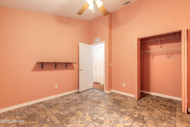 1927 Orange Tree Dr, Edgewater, FL 32141 - unfurnished bedroom featuring stone finish flooring, baseboards, a closet, a high ceiling, and a ceiling fan