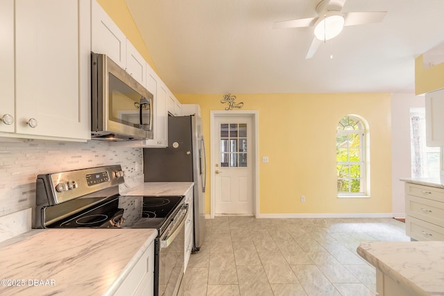 1927 Orange Tree Dr, Edgewater, FL 32141 - kitchen with appliances with stainless steel finishes, decorative backsplash, white cabinets, light stone counters, and vaulted ceiling