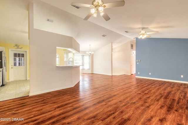 1927 Orange Tree Dr, Edgewater, FL 32141 - unfurnished living room with a ceiling fan, vaulted ceiling, a chandelier, wood finished floors, and a sink