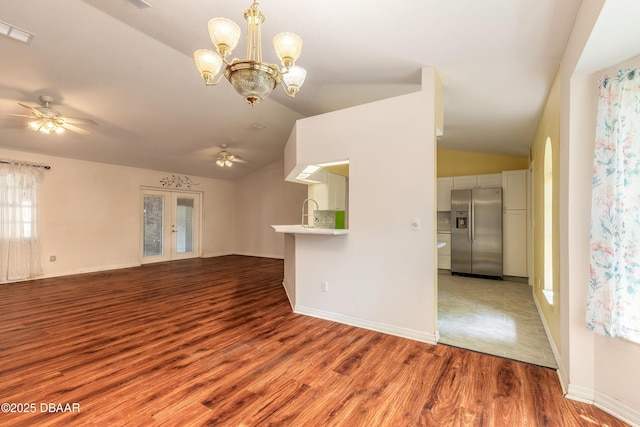 1927 Orange Tree Dr, Edgewater, FL 32141 - unfurnished living room featuring lofted ceiling, ceiling fan, wood finished floors, a chandelier, and baseboards