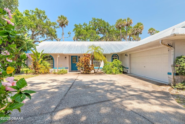 1927 Orange Tree Dr, Edgewater, FL 32141 - ranch-style house featuring stucco siding, concrete driveway, a garage, and metal roof