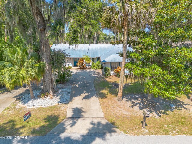1927 Orange Tree Dr, Edgewater, FL 32141 - view of front of house with concrete driveway, a porch, and metal roof
