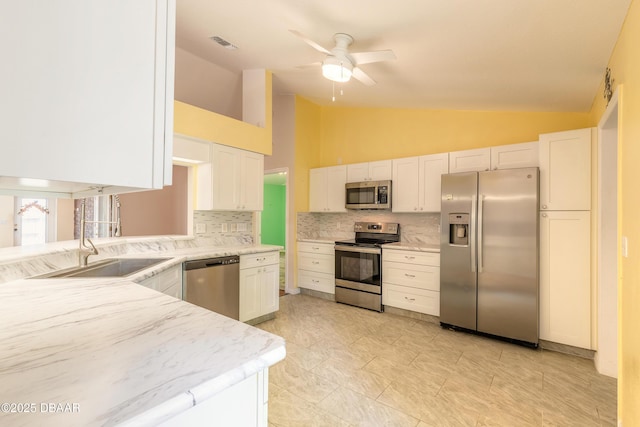 1927 Orange Tree Dr, Edgewater, FL 32141 - kitchen featuring appliances with stainless steel finishes, tasteful backsplash, a ceiling fan, white cabinetry, and light stone countertops