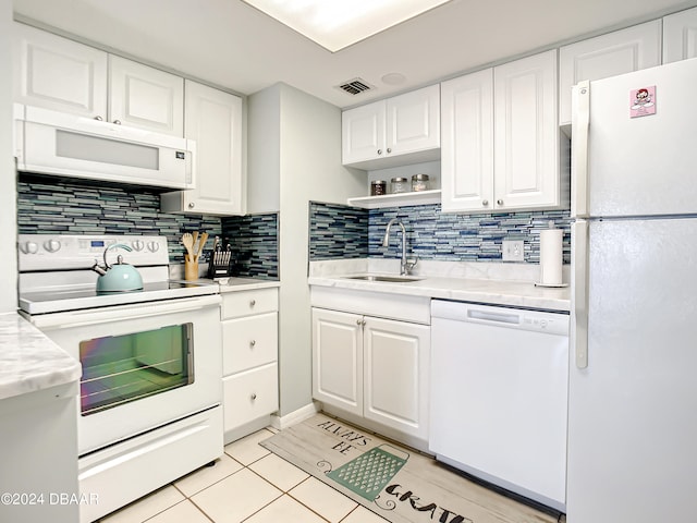 kitchen with white cabinetry, light tile patterned floors, decorative backsplash, sink, and white appliances