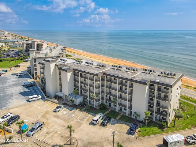 birds eye view of property with a water view and a beach view