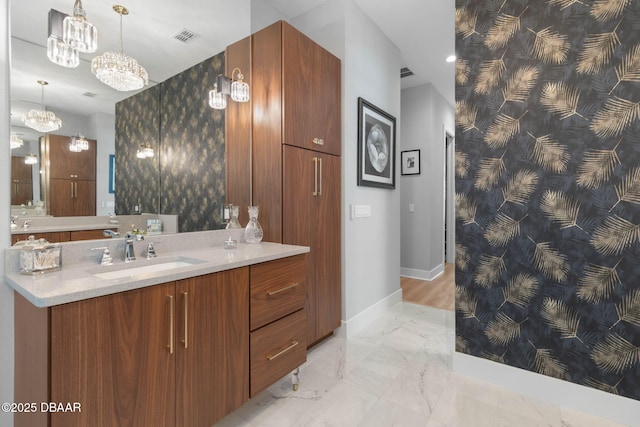 129 Seaside Pt, Flagler Beach, FL 32136 - full bath featuring wallpapered walls, an accent wall, a chandelier, vanity, and marble finish floors