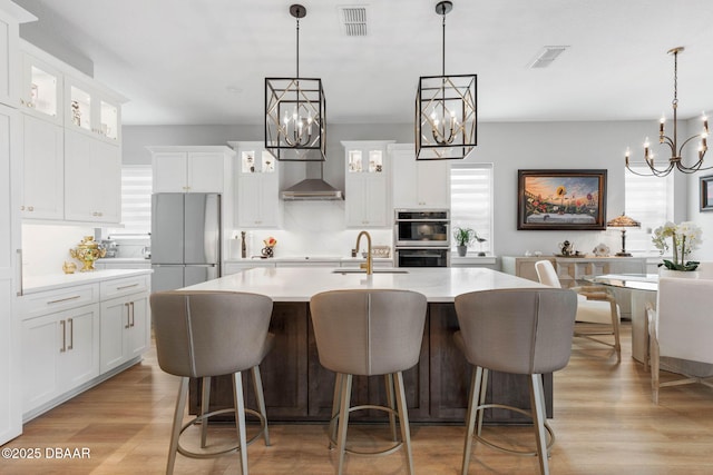 129 Seaside Pt, Flagler Beach, FL 32136 - kitchen featuring a chandelier, stainless steel appliances, light countertops, and light wood finished floors