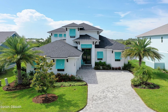 129 Seaside Pt, Flagler Beach, FL 32136 - view of front of home with a shingled roof, a front yard, and driveway