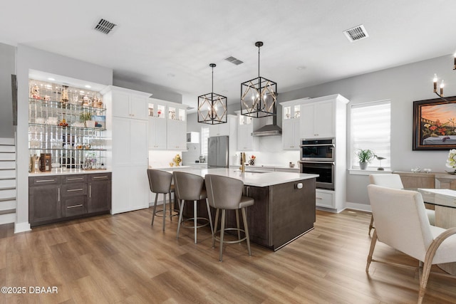 129 Seaside Pt, Flagler Beach, FL 32136 - kitchen featuring appliances with stainless steel finishes, light countertops, light wood-style floors, a chandelier, and a center island with sink