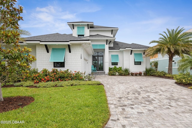 129 Seaside Pt, Flagler Beach, FL 32136 - prairie-style home featuring a shingled roof, a front yard, and driveway