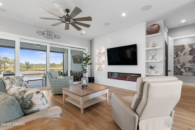 129 Seaside Pt, Flagler Beach, FL 32136 - living area featuring ceiling fan, wood finished floors, a fireplace, and recessed lighting