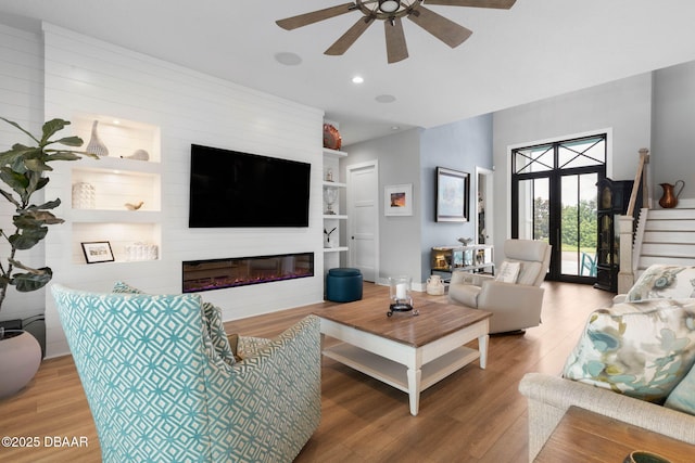 129 Seaside Pt, Flagler Beach, FL 32136 - living area with wood finished floors, a ceiling fan, built in features, a large fireplace, and recessed lighting