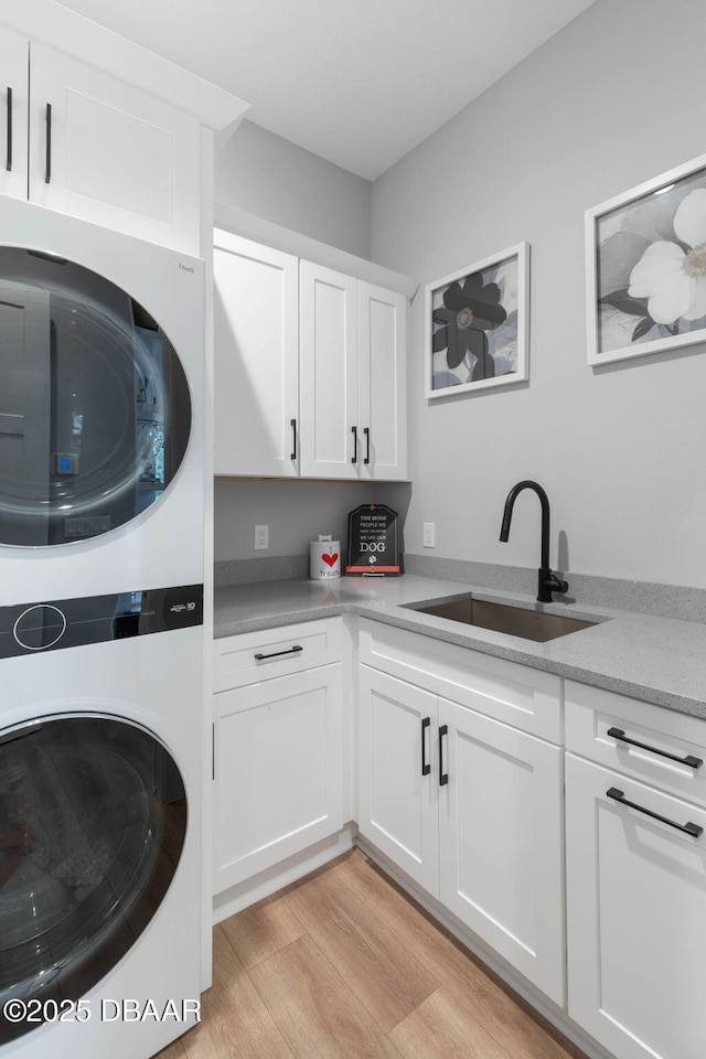 129 Seaside Pt, Flagler Beach, FL 32136 - laundry room featuring stacked washer / drying machine, cabinet space, and light wood finished floors