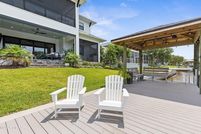 129 Seaside Pt, Flagler Beach, FL 32136 - deck featuring ceiling fan, a sunroom, a lawn, and a water view
