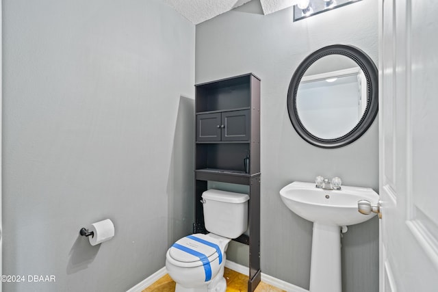 bathroom featuring a textured ceiling and toilet