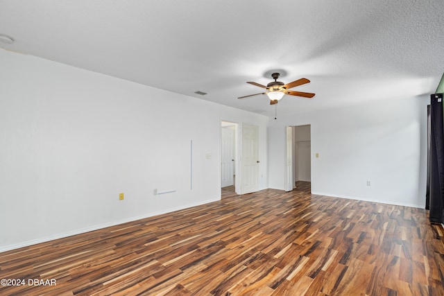 spare room with ceiling fan, dark wood-type flooring, and a textured ceiling