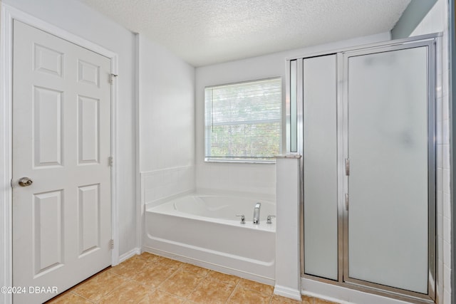 bathroom with tile patterned flooring, plus walk in shower, and a textured ceiling