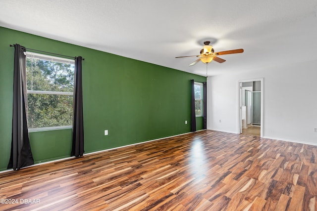 unfurnished room featuring ceiling fan, a healthy amount of sunlight, a textured ceiling, and hardwood / wood-style flooring