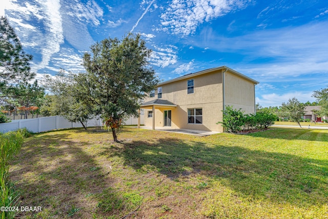 rear view of house with a yard and a patio area