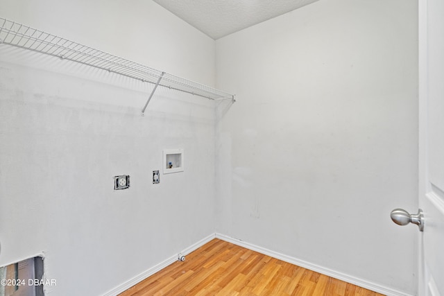 laundry area featuring washer hookup, hookup for an electric dryer, a textured ceiling, and hardwood / wood-style flooring